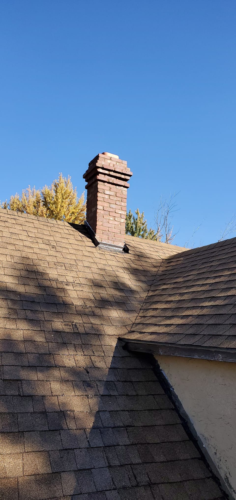 Rebuilt red brick chimney with stepped corbelled courses and a stone cap in Colonial style