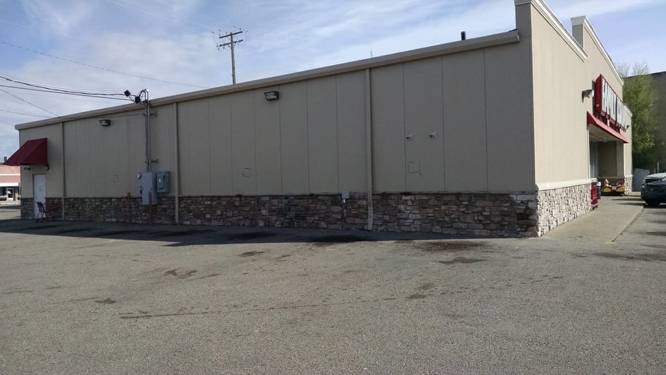 Side wall of the Family Dollar building with stone veneer wainscot running its full length