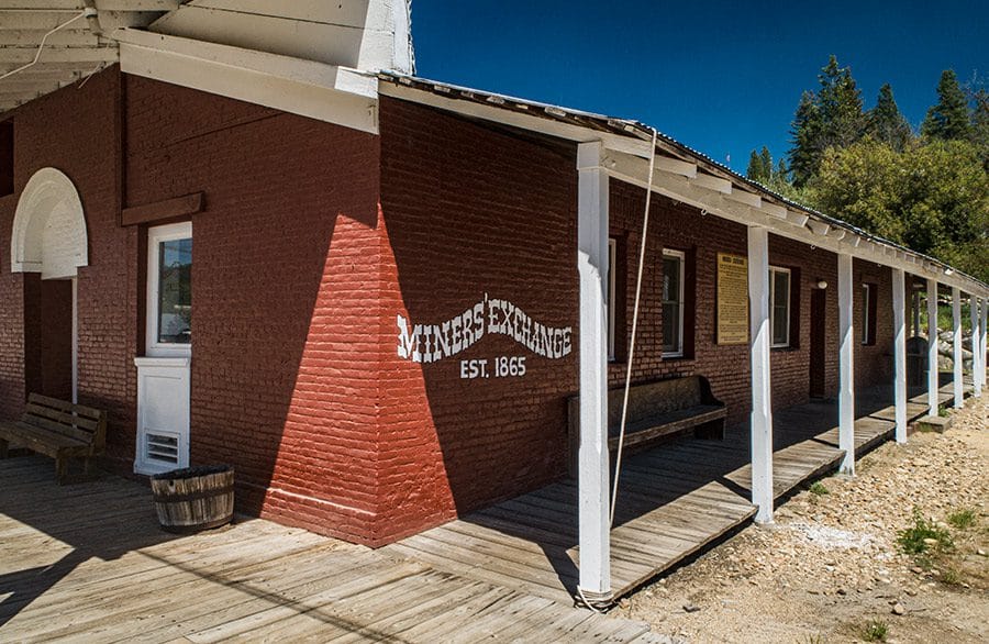 Restored red brick Miners Exchange building in Idaho City with Est. 1865 lettering and boardwalk