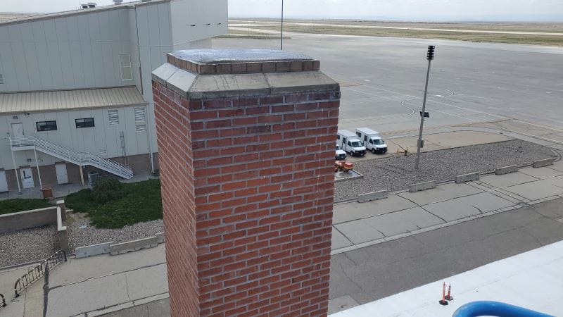 Finished brick chimney with its new cap and crown beside Hangar 208 at Mountain Home Air Force Base