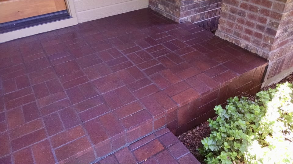 Brick porch and step in a deep red wet-look sealed finish next to a brick column
