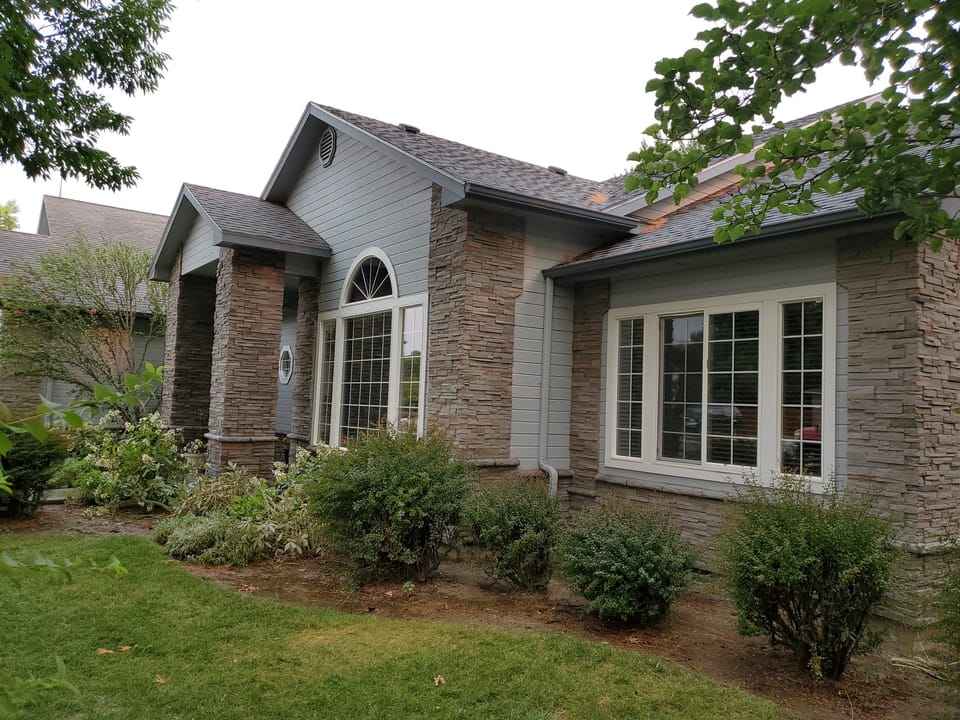 Stacked stone veneer on the entry columns and wainscot below the front bay window