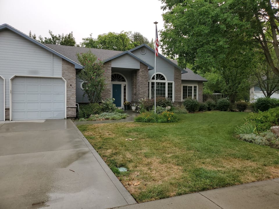 Full front of the house after stone veneer, with stone at the entry columns and garage corner